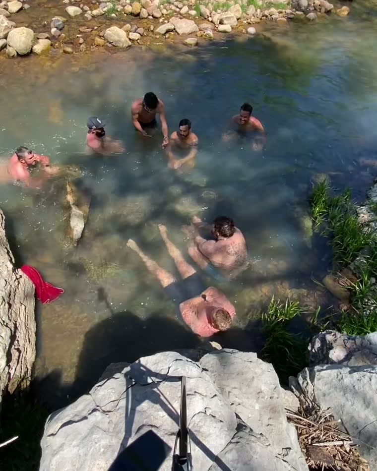 People in a river between rocks