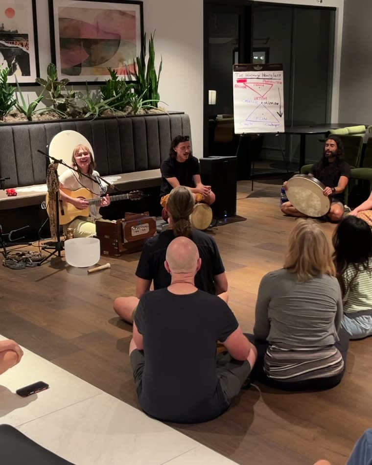 A large mixed circle gathered around live music